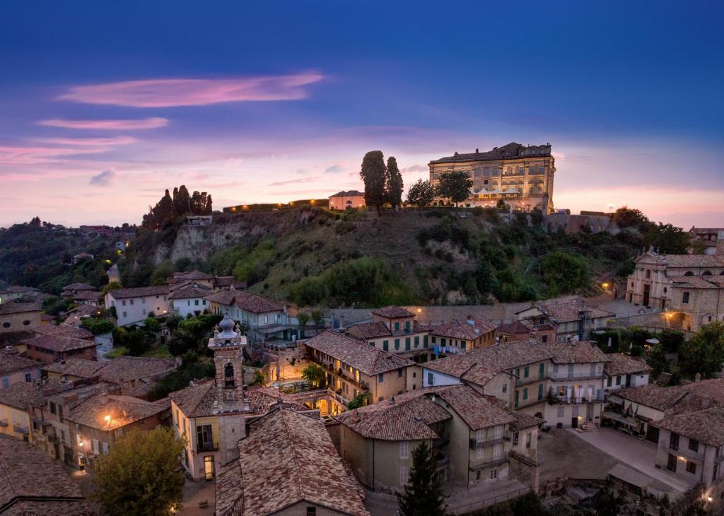 瓜热讷Il Cortile di San Michele的享有小镇和山丘上城堡的景色