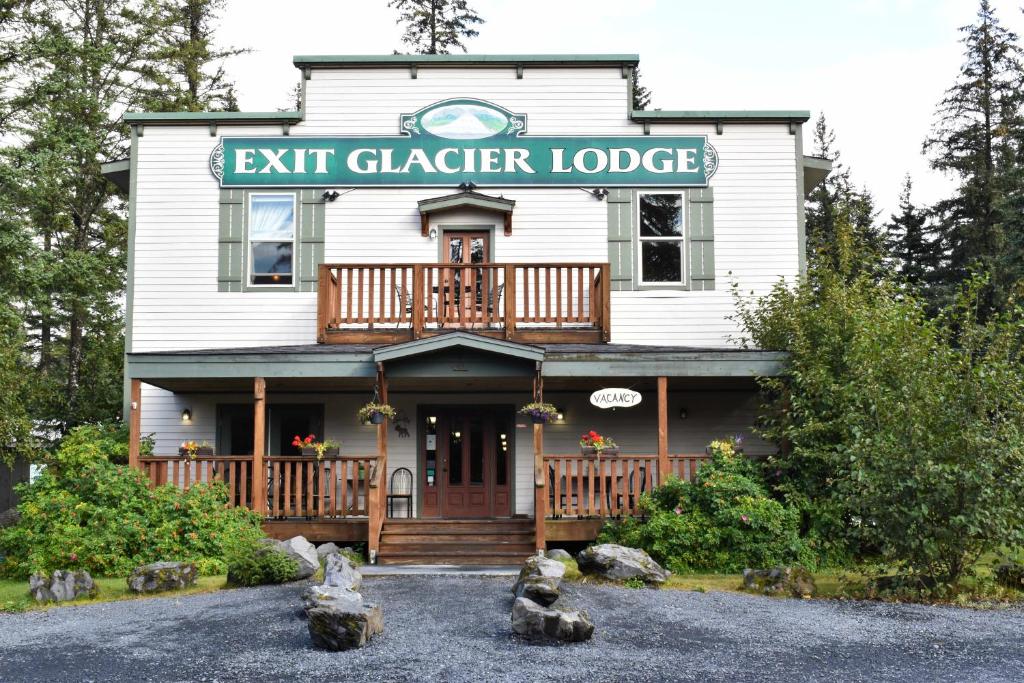 西沃德Exit Glacier Lodge的白色的房子,上面有出口冰川小屋标志