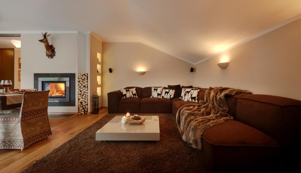 维拉巴萨Crioli Dolomiti Lodge的客厅配有沙发和桌子