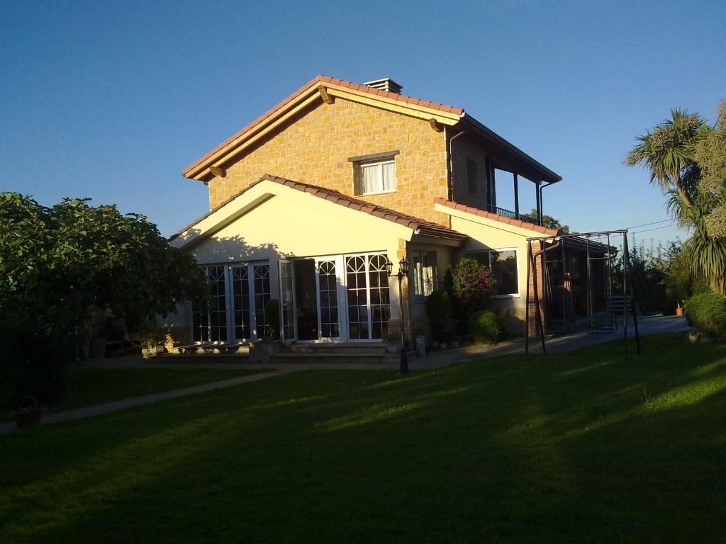 Quintueles罗斯奥贝托斯酒店的前面有草坪的大砖房子