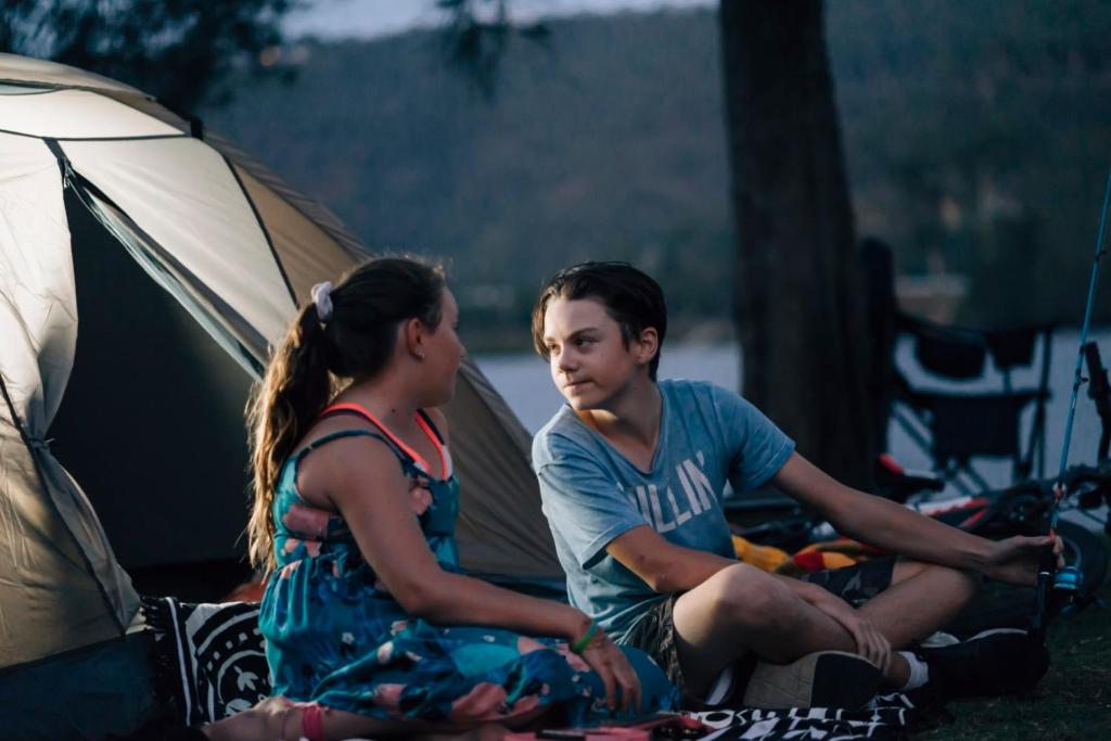 威斯曼菲瑞德尔里奥河畔度假酒店 的坐在帐篷旁边的男人和女人