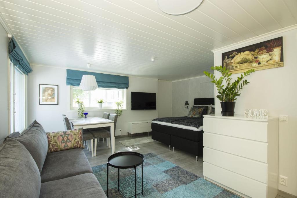 万塔Airport Mint House Studio的客厅配有沙发和一张位于房间的床