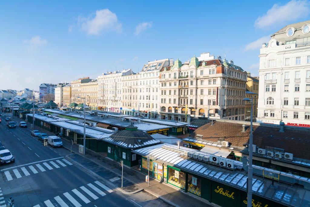 维也纳Vienna Residence, Naschmarkt - Karlsplatz的一条城市街道,有火车站和建筑