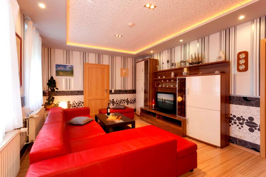 岑平Fewo Höft Zempin nur 500m vom Ostseestrand entfernt的客厅配有红色沙发和电视
