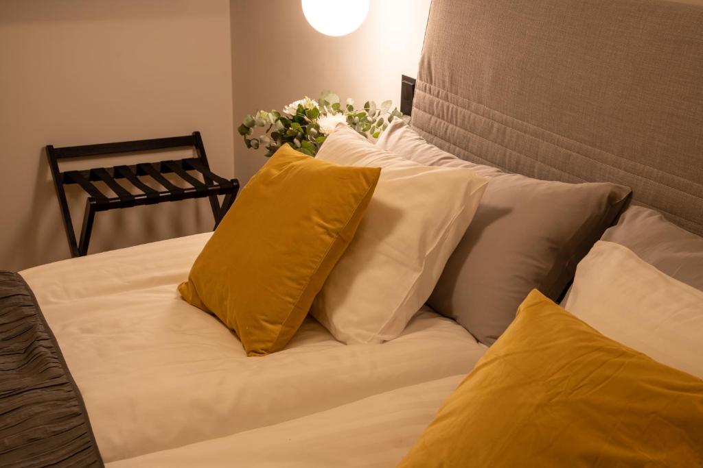 法尔雪平Hotell Syfabriken的床上有黄色枕头的床