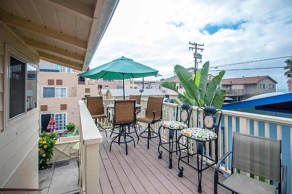 圣地亚哥咪咪和娜娜的海滩度假屋的阳台配有桌椅和遮阳伞。