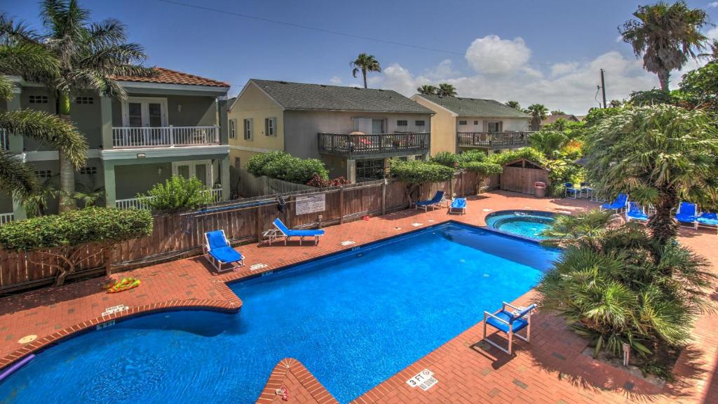 南帕诸岛Ventura Condominiums #204的享有带蓝椅和棕榈树的游泳池的顶部景致