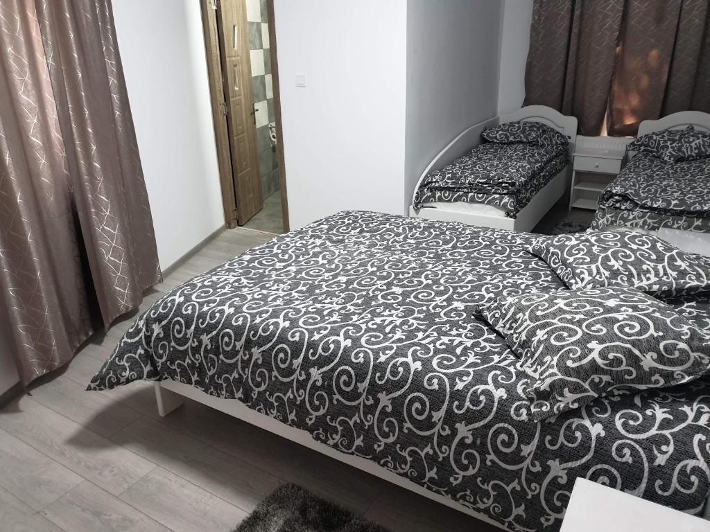 BîrladPensiunea Gallamar的一间卧室配有两张黑白床单