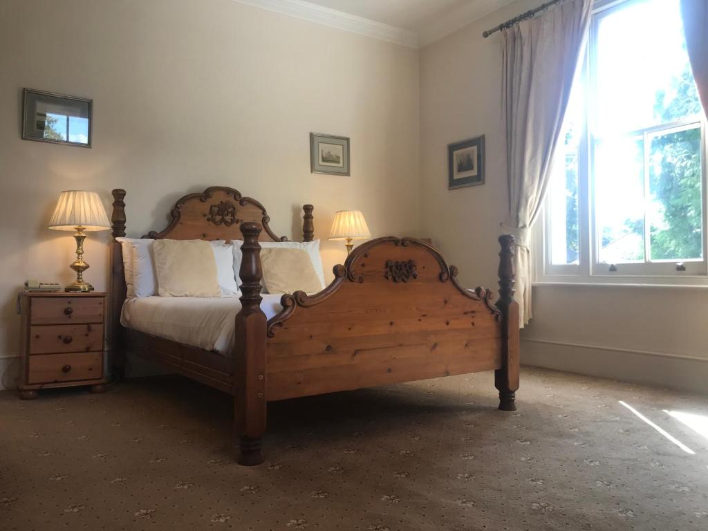 梅登黑德Norfolk House的一间卧室设有一张木床和一个窗户。