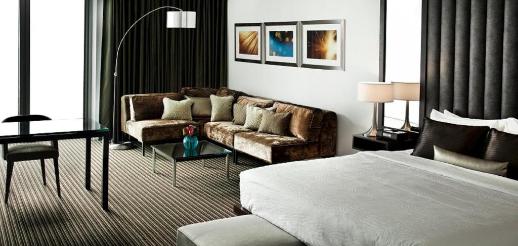 达拉斯陆梦酒店的一间卧室配有一张床、一张沙发和一张桌子