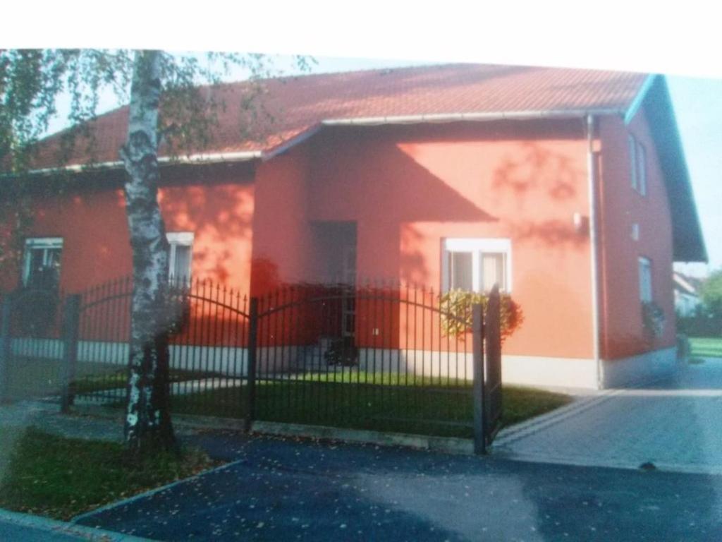 温科夫齐Kuća za odmor Ruža, Vinkovci的前面有栅栏的红色房子