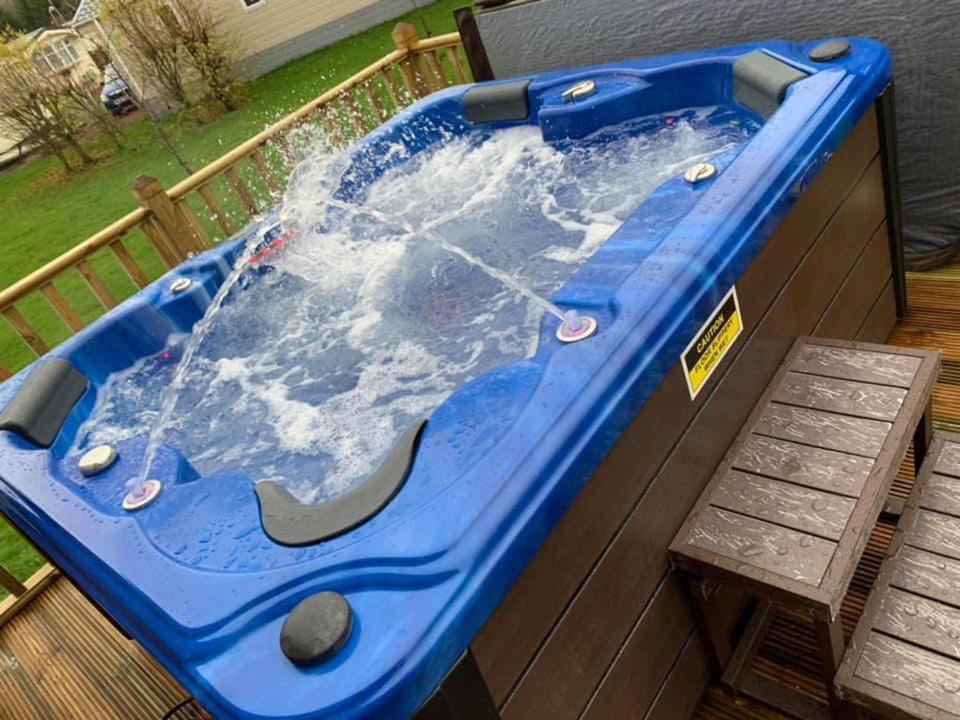 SwarlandTranquil Lodge hot tub and free golf的甲板上的热水浴池,配有长凳
