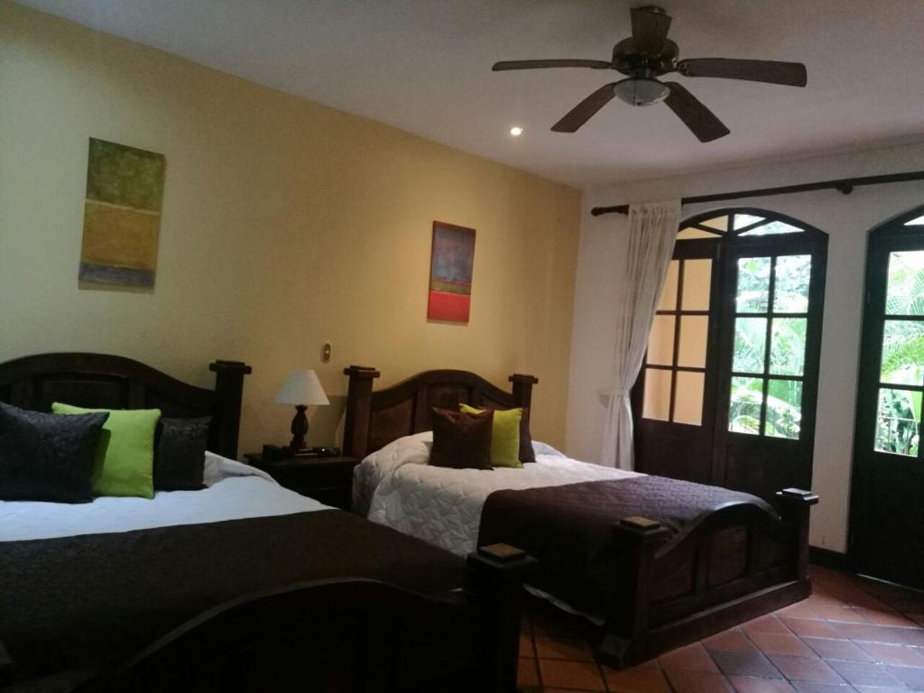 San Antonio特拉普家庭乡村旅馆的一间卧室配有两张床和吊扇