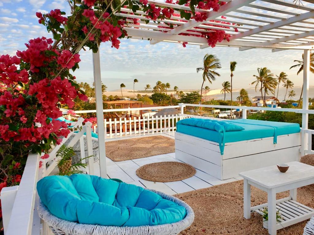 杰里科科拉Pousada Duna Beach的庭院设有蓝色的椅子、桌子和鲜花