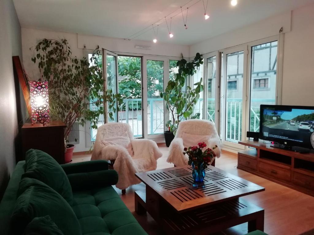 米卢斯LE KATZALA的客厅配有白色椅子和电视