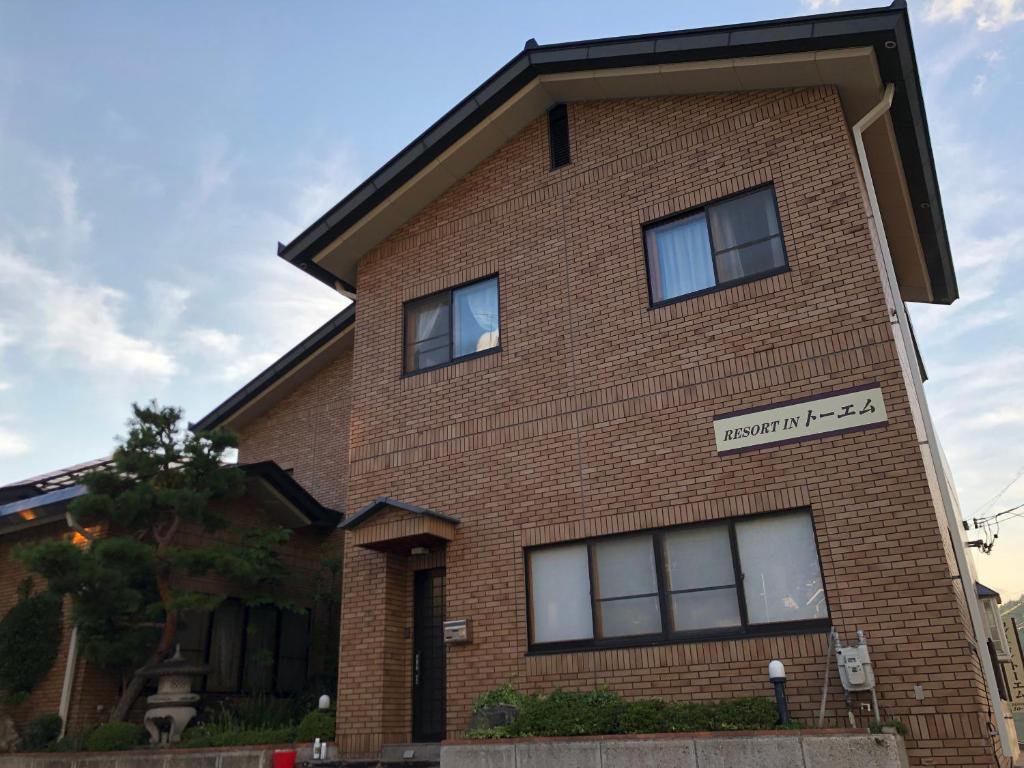 野沢Apartment at Toemu Nozawa的砖砌的建筑,上面有标志