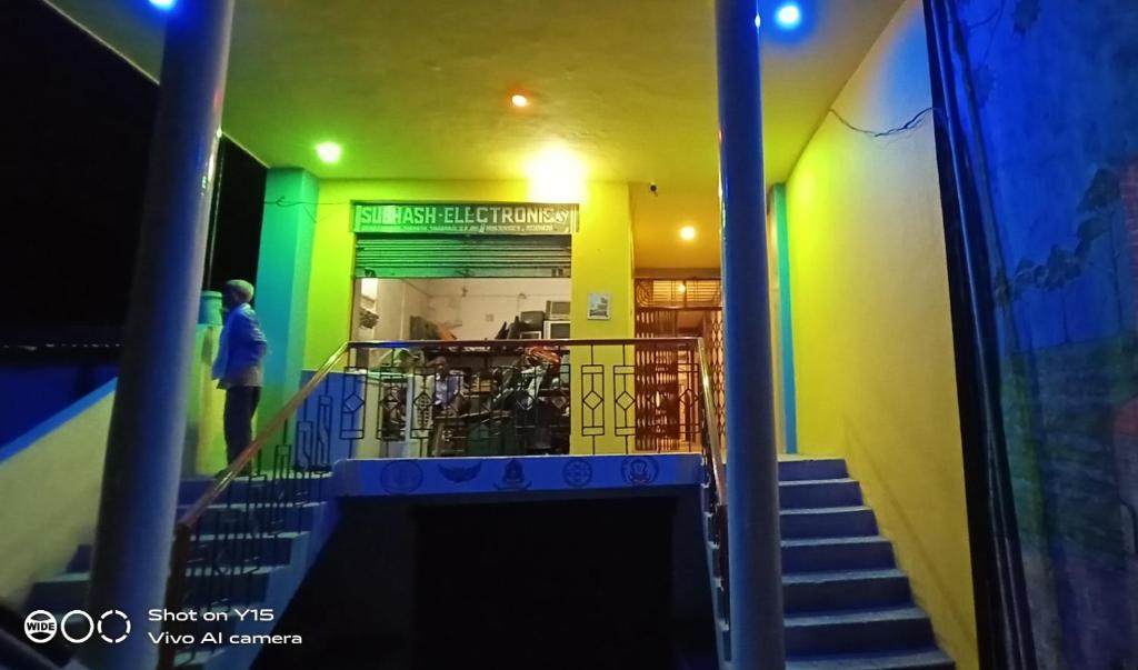 瓦拉纳西MAYUR paying Guest house的通往拥有绿色和黄色墙壁的建筑的楼梯