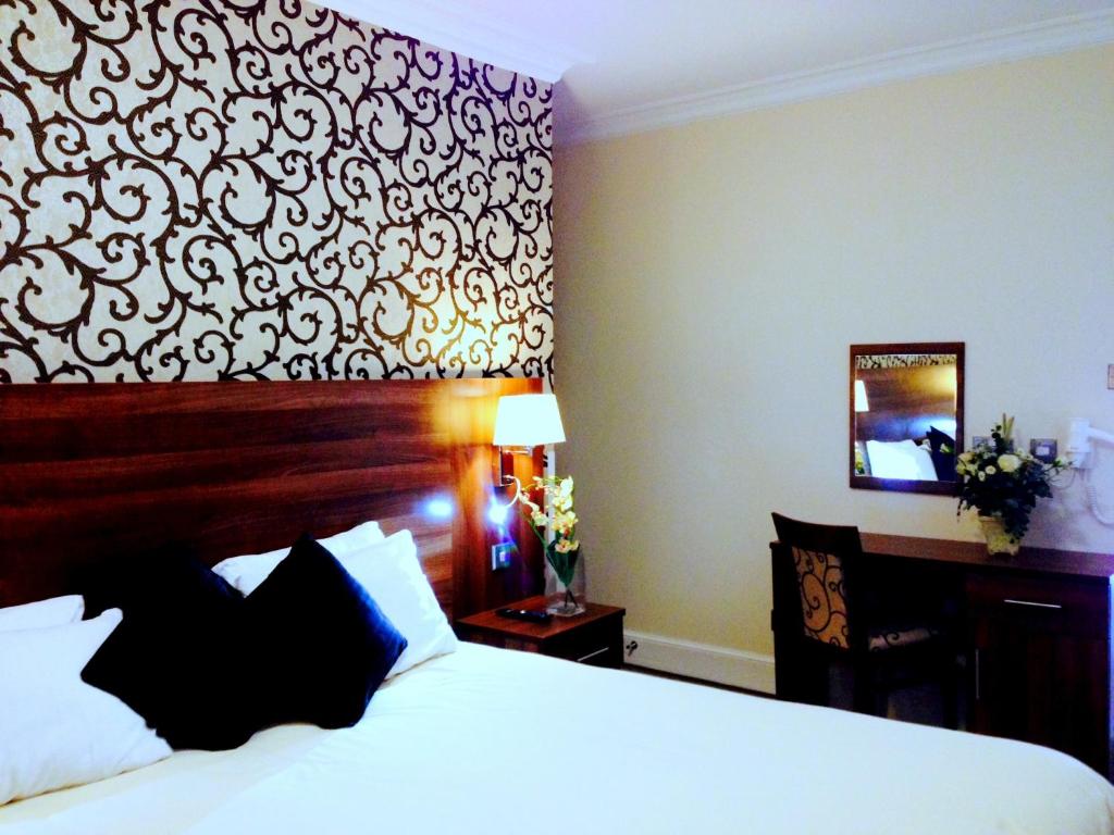 伍尔弗汉普顿伊利别墅酒店的配有一张床和一张书桌的酒店客房