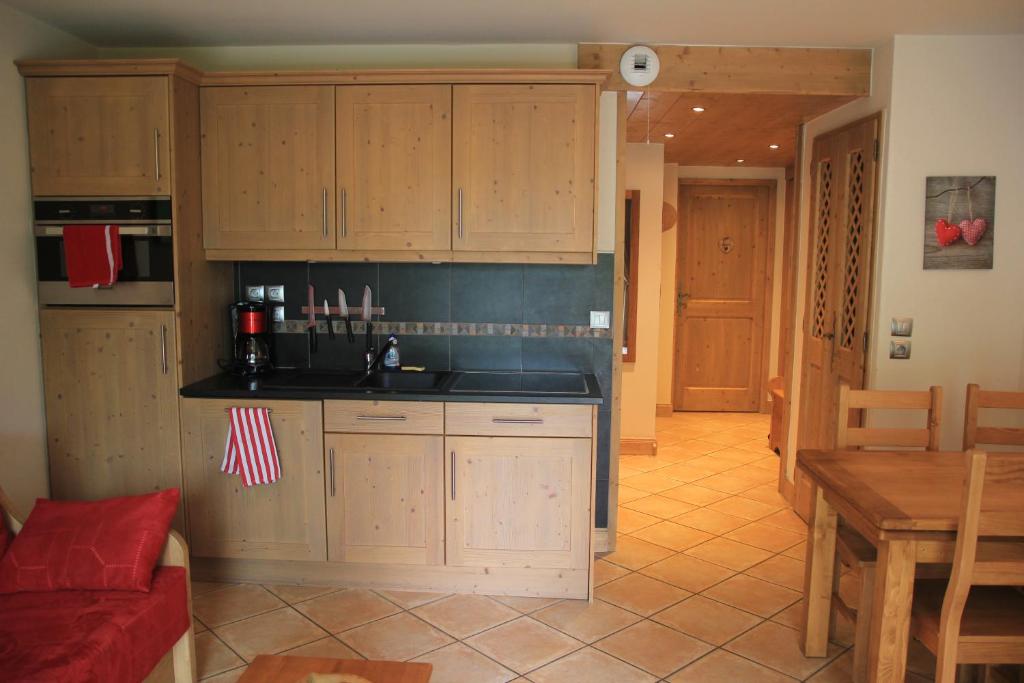 雷加霍斯达哈施At Home的厨房配有木制橱柜、红色沙发和桌子