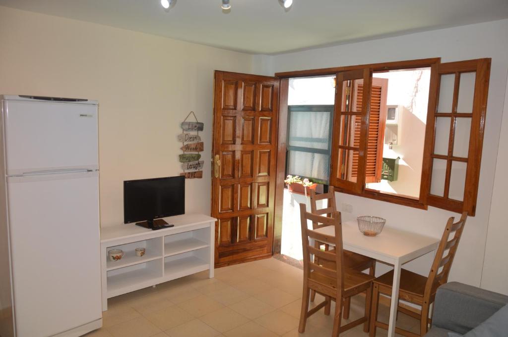 戈梅拉岛圣塞瓦斯蒂安La Niña的一间带桌子和电视的客厅以及一间厨房。