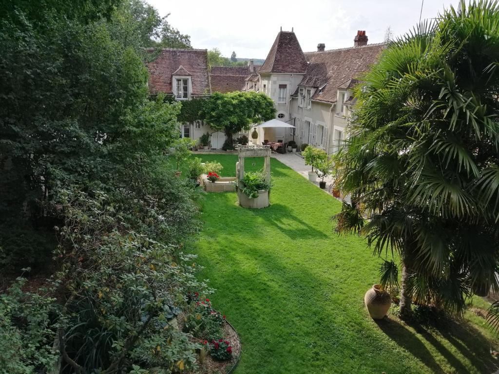 阿普瓦尼Chambres et Tables d'hôtes du Puits d'Athie的一座带绿草和树木的庭院