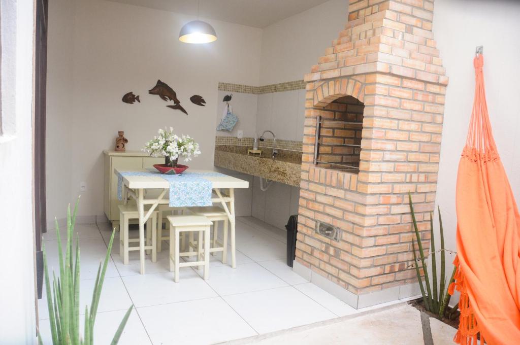 圣米格尔-杜戈斯托苏Cardeiro Flat-S.M.Gostoso的厨房配有砖砌壁炉、桌子和水槽