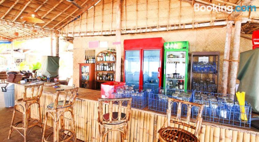 比纳里姆Blue Corner Beach Huts & Restaurant的餐厅设有酒吧,配有椅子和苏打水机