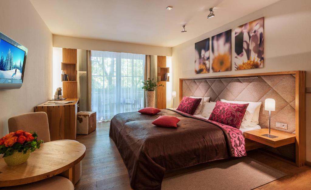 奥巴拉马高马克西米利安酒店的一间卧室配有一张大床和一张桌子