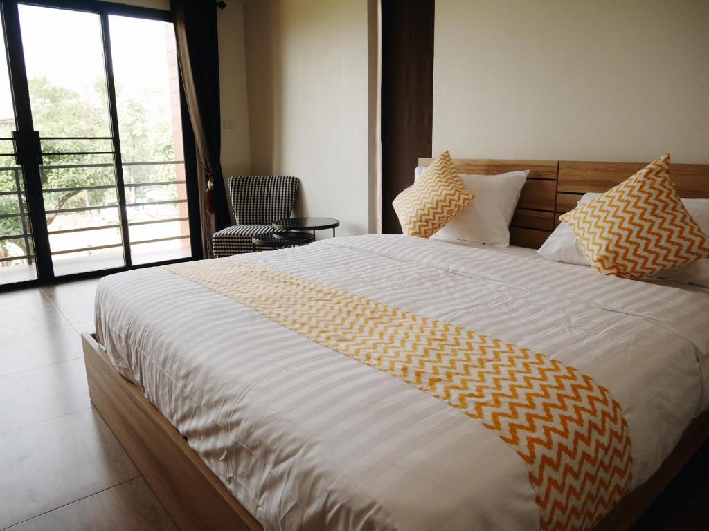 北榄坡บ้านเพลิน的一间卧室配有一张带黄白色床单的大床