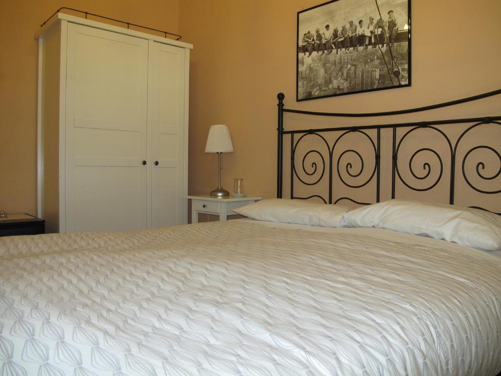 罗马桑塔克罗斯酒店的一间卧室配有一张带白色床罩的大床