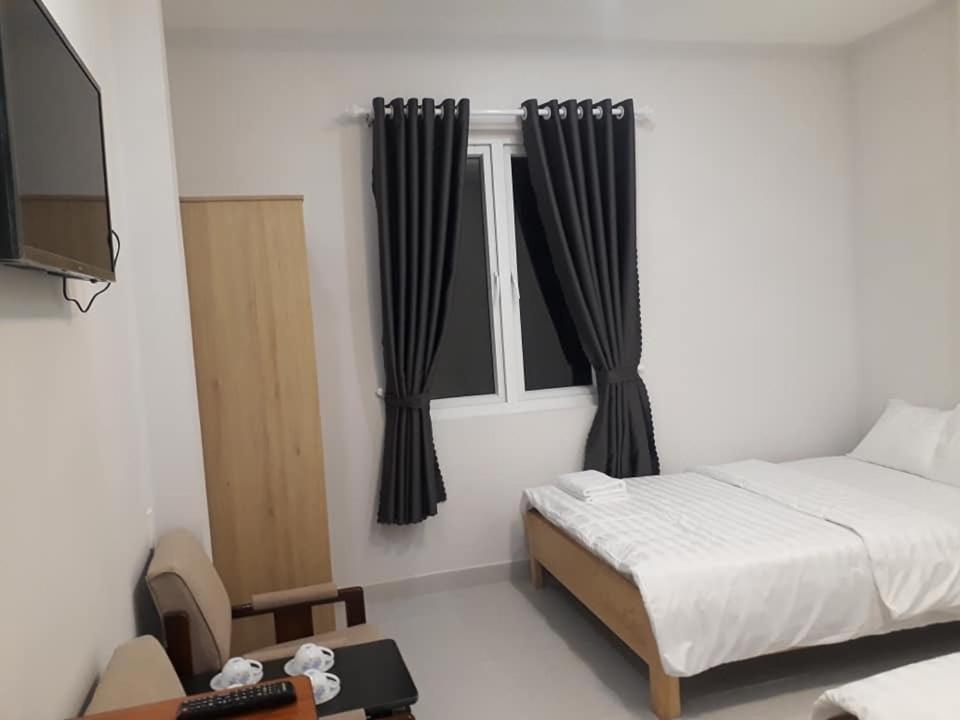 大叻Guest house Hai Cô Chú的一间卧室配有床和带窗帘的窗户
