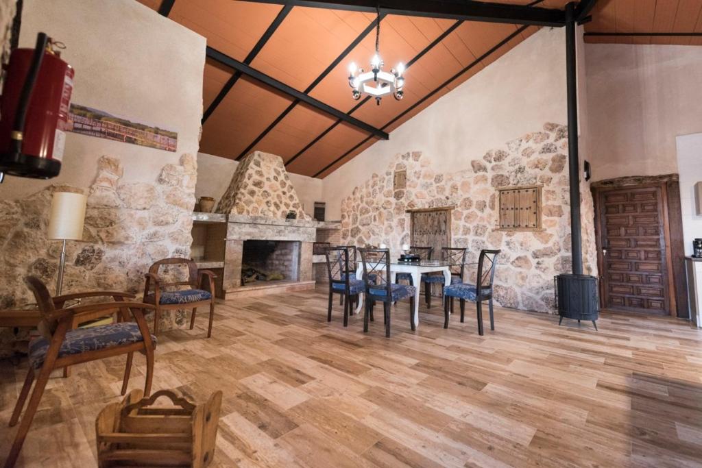 代米耶尔Casa Rural Las Caleras的一间设有桌椅和石墙的用餐室