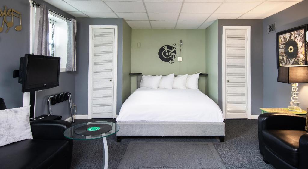 纳什维尔Music Valley Studio - No Fees - Opryland Area的一间卧室配有一张床、一张沙发和一台电视。