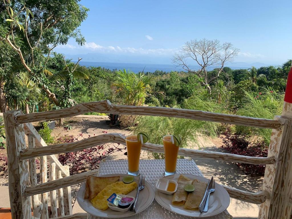 珀尼达岛La Colina Bungalow的一张桌子,上面放着两盘食物和橙汁