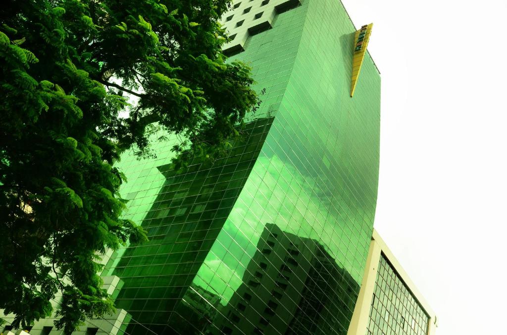 达卡71酒店的一座高大的绿色建筑,有很多窗户