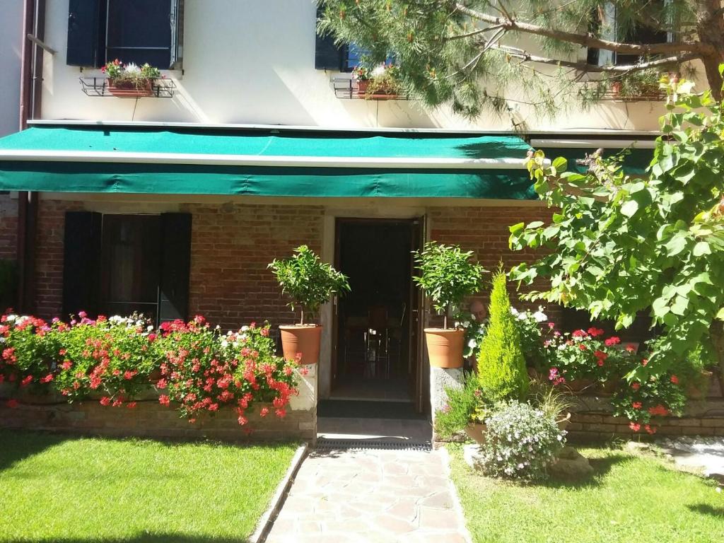 威尼斯霍图斯住宿加早餐旅馆的一座有绿色遮阳篷和一些花卉的建筑