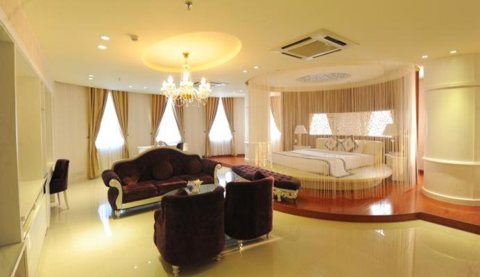 槟知越南Uc酒店的一个带床和沙发的大客厅
