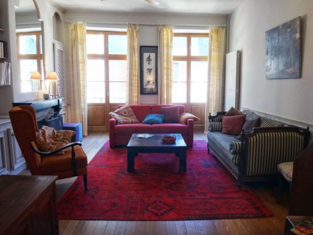 拉沙里泰Gîte de la Galerie du Pont的客厅配有红色沙发和红色地毯
