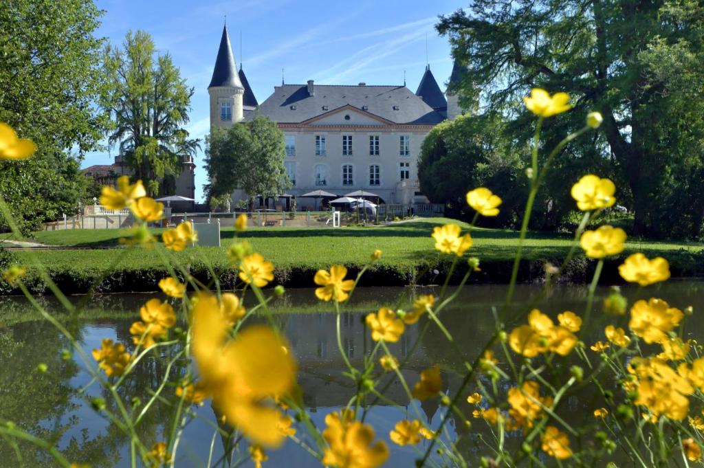 博埃Logis Hotels - Château Saint Marcel的前方有黄色花的建筑