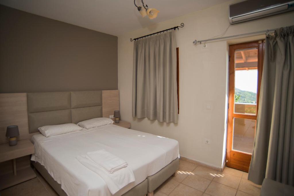 ChortátaT'Aloni的卧室配有白色的床和窗户。