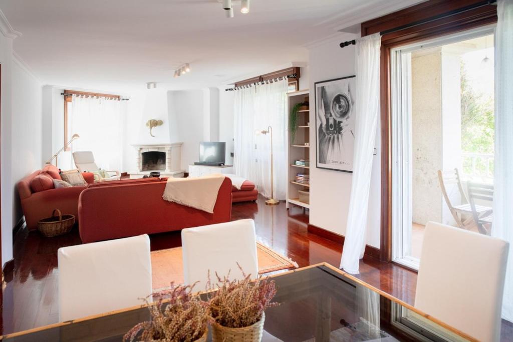 OyaCanido, Vigo, Rias Baixas的客厅配有红色沙发和白色椅子