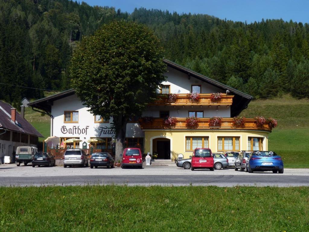 Rohr im GebirgeGasthof Furtner的一座大型建筑,前面有汽车停放