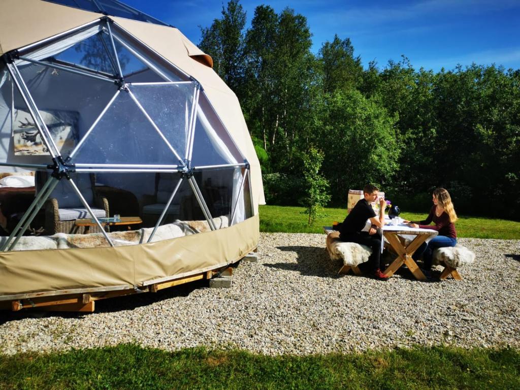 拉克塞尔夫Wild Caribou Dome的一群人坐在帐篷里的桌子上