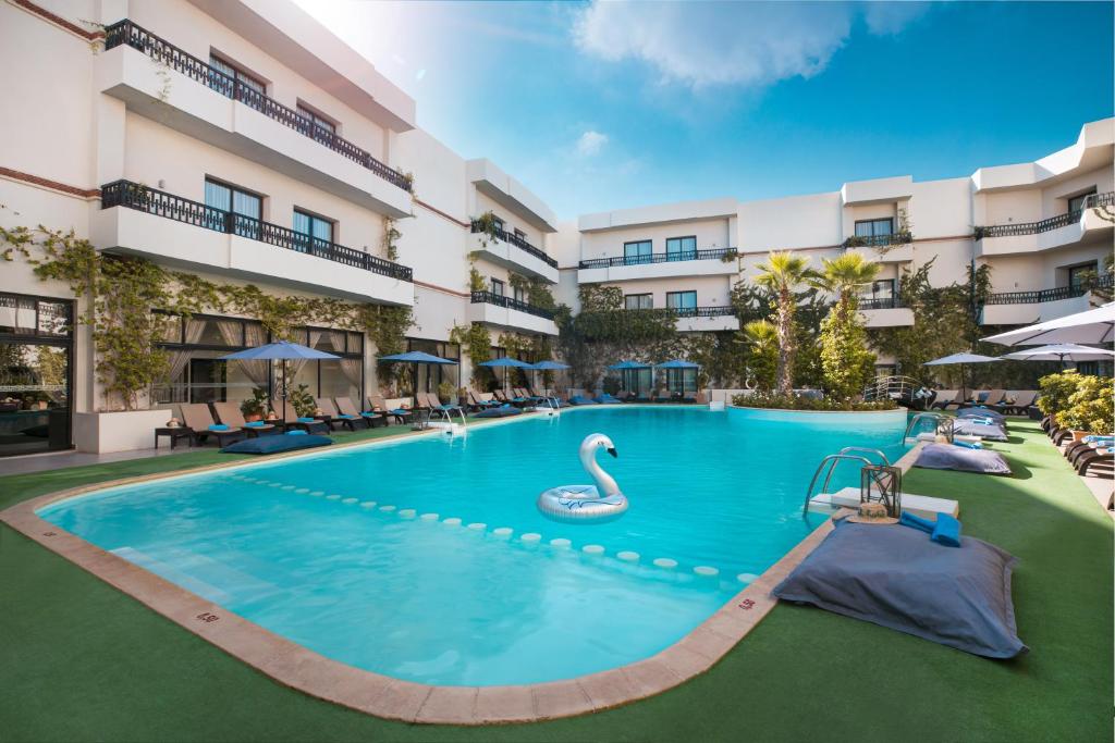 马拉喀什凯克精品酒店&Spa的中间有天鹅的酒店游泳池