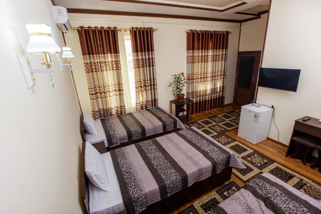 希瓦Xurshidabonu Guest House的一间卧室配有两张床和一张桌子。