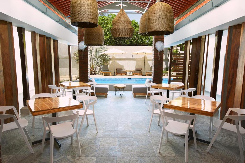 松索纳特Villavela Hotel Boutique的一间带桌椅的餐厅和一个游泳池