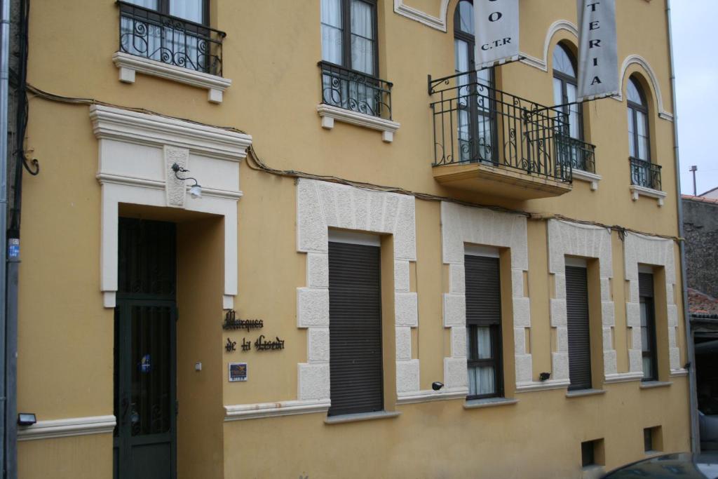 费尔莫塞列Hotel Rural La Enoteca del Marques的黄色的建筑,设有窗户和阳台