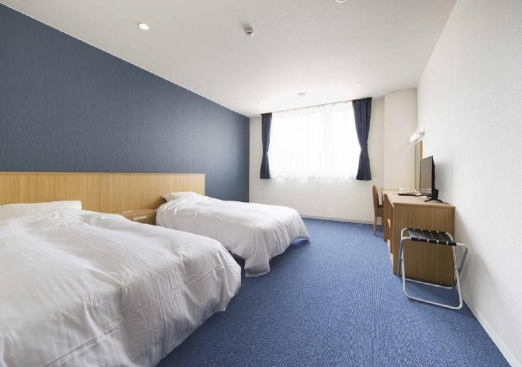 东松岛Higashimatsushima - Hotel / Vacation STAY 43089的酒店客房设有两张床和电视。