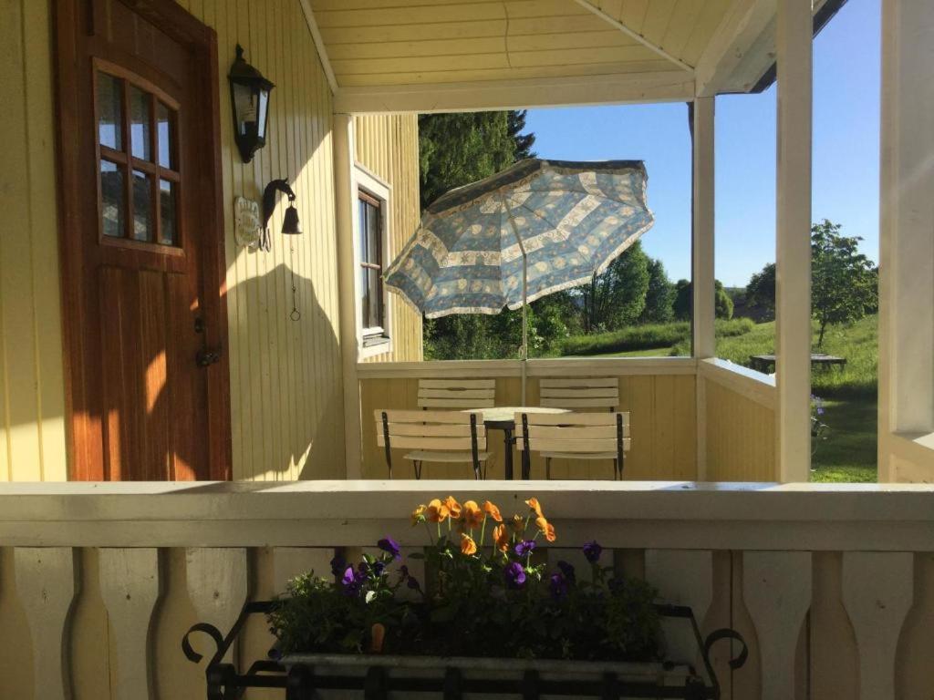 厄斯特松德Lilla Lilo Gården的房屋内带长凳和遮阳伞的门廊