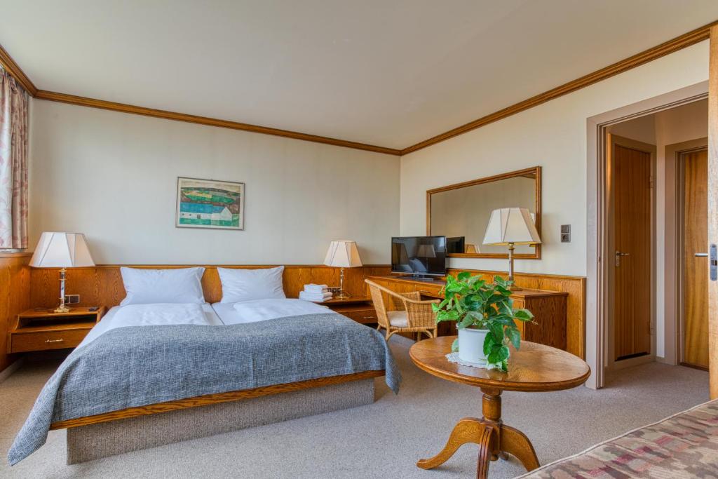 普特加登FF&E Hotel Dania的酒店客房配有一张床铺和一张桌子。